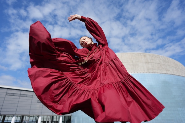 Immagine di esempio con il ritratto di una donna in abito rosso che balla con eleganza.